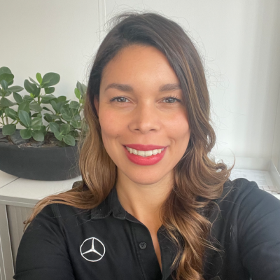 Selfie einer Person im Büro mit langen dunklen Haaren und einem schwarzen Hemd mit Mercedes-Benz Logo